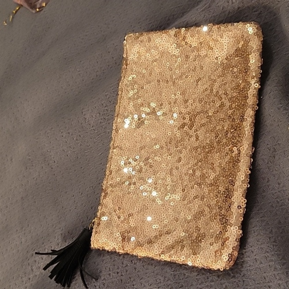 Ipsy make up bag. Gold sequin on front with black tassel.  Black on back. NWT